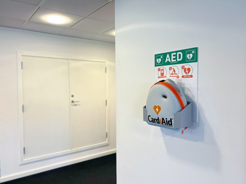 Hjertestarter fra Securitas, der er monteret indendørs på en væg i et kontormiljø Hjertestarter fra Securitas, der er monteret indendørs på en væg i et kontormiljø